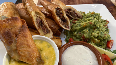 SMOKED BRISKET TAQUITOS WITH FRESH GUACAMOLE AND SPICY CHEESE SAUCE