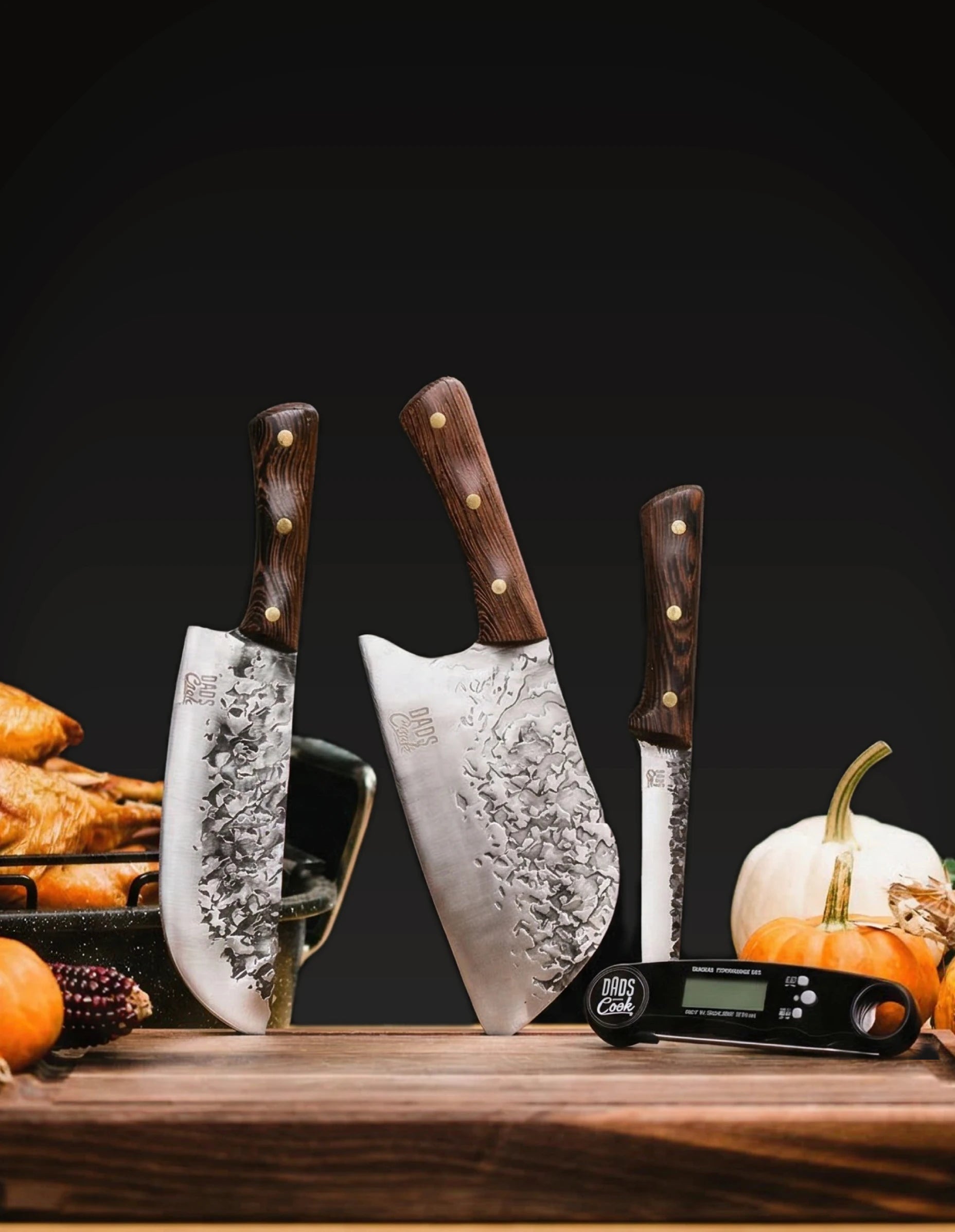 BBQ Beast Kit that includes the Chef knife, Cleaver knife, boning knife, and instant thermometer, all on wooden cutting board on black background
