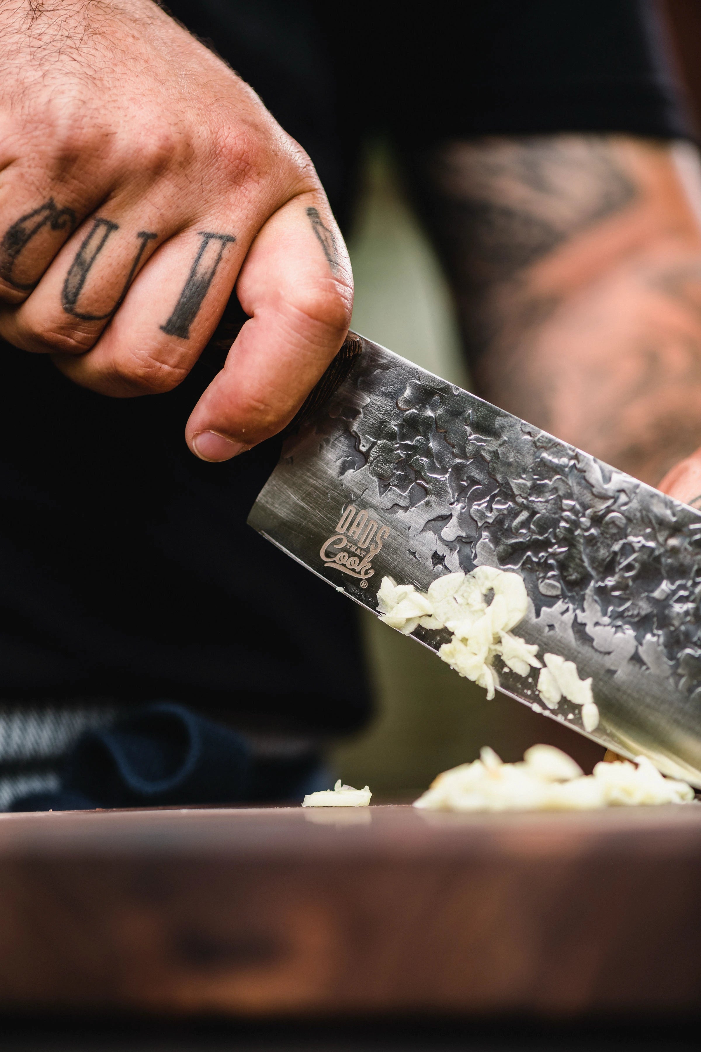 Man cutting garlic with dads that cook chef knife