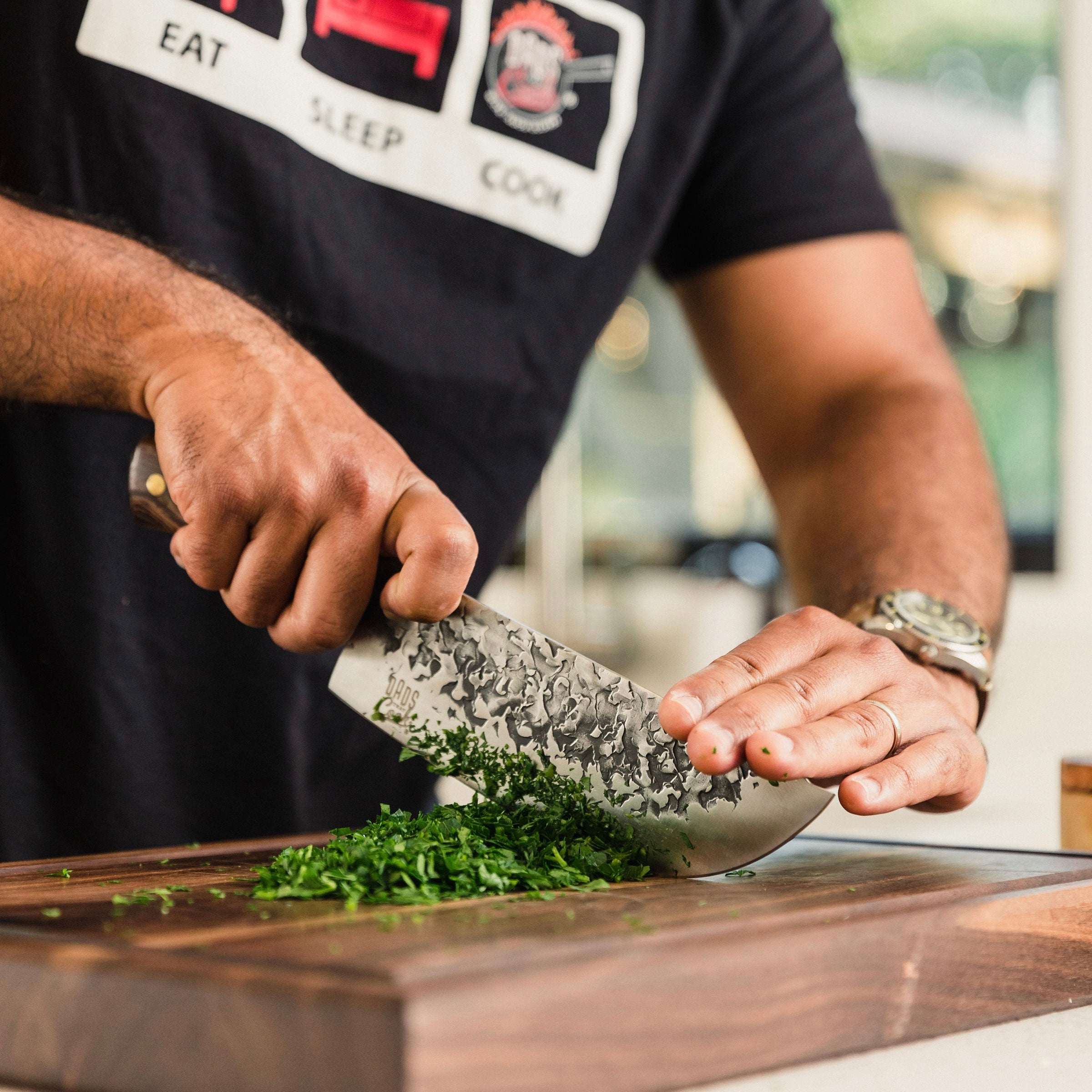 Dad using the Dad's That Cook Chef Knife to cut some greens on the Dad's That cook Wooden Cutting Board