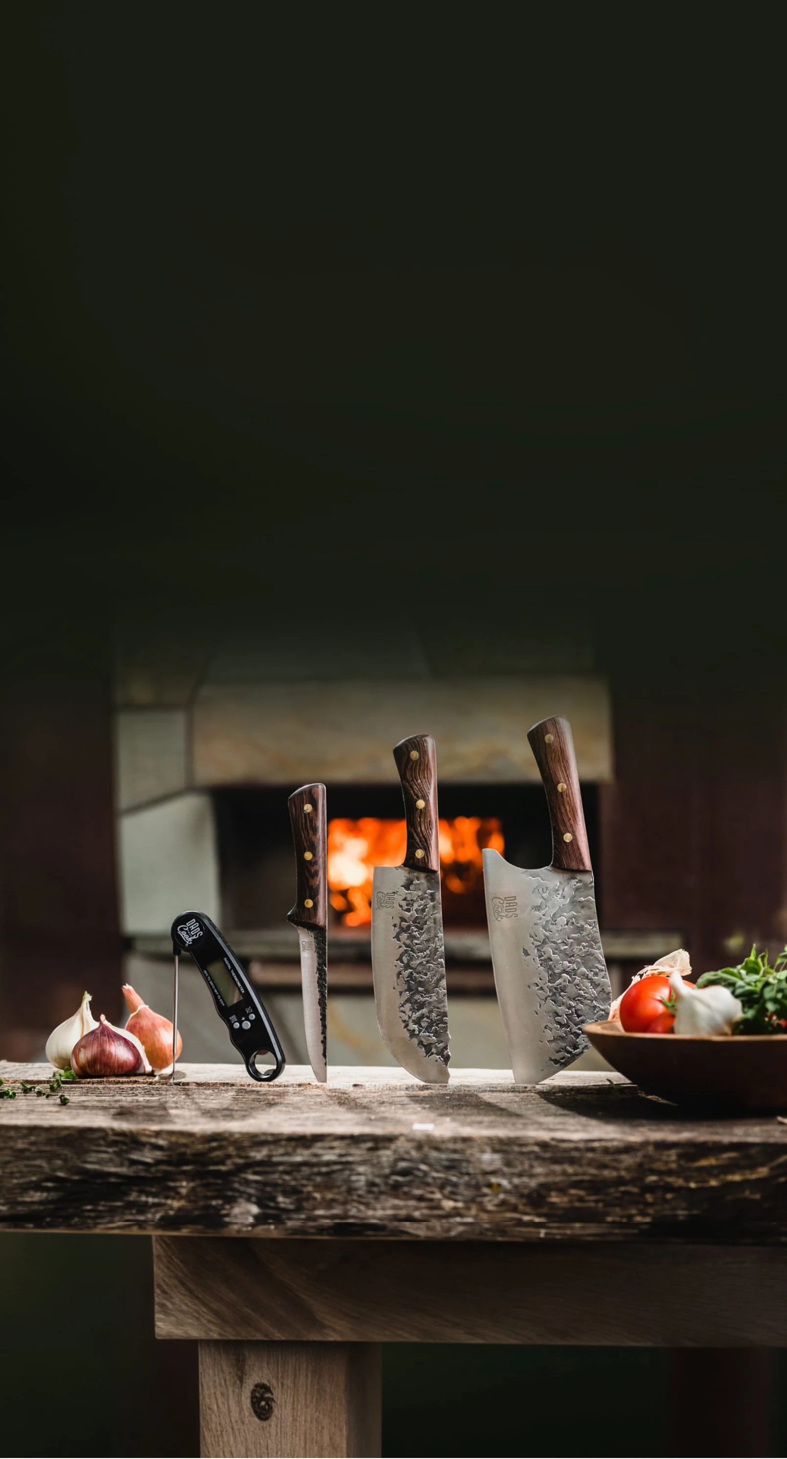 Three dads that cook knives on a wooden table with a fireplace in the background
